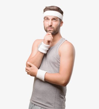 genç yakışıklı sporcu gri kolsuz bluz ile düşünme. Tek renkli arka planı izole kişi.