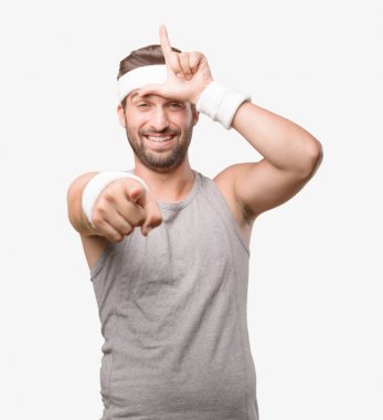 Genç yakışıklı sporcu işaretleme açık gri tank top ile. Tek renkli arka planı izole kişi.