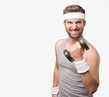 Genç yakışıklı sporcu bir halterle gri tank top kaldırma. Tek renkli arka planı izole kişi.