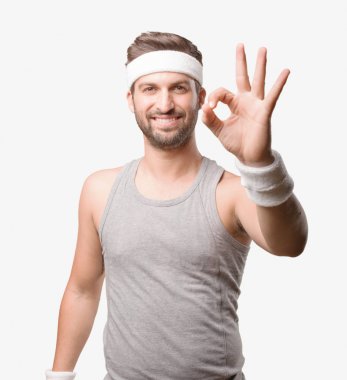 Genç yakışıklı sporcu gri tank top ile Tamam işareti ile. Tek renkli arka planı izole kişi.
