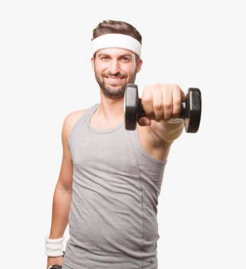 Genç yakışıklı sporcu bir halterle gri tank top kaldırma. Tek renkli arka planı izole kişi.