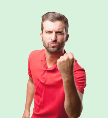 Yakışıklı genç bir kırmızı polo gömlek giymiş bir zaferini kutluyor. Tek renkli arka planı izole kişi.