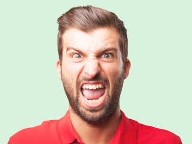 Genç yakışıklı kızgın ifade ve kırmızı bir polo gömlek giymiş bağıran adam. Tek renkli arka planı izole kişi.