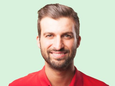 Kırmızı bir polo gömlek gülümseyen yakışıklı delikanlı. Tek renkli arka planı izole kişi.