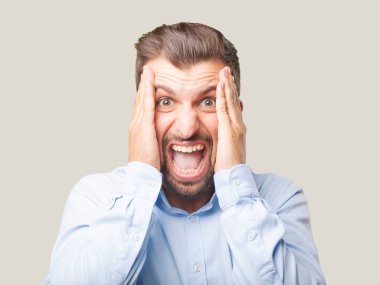 genç yakışıklı adam mavi t gömlek ve mutlu ya da memnun ifade şaşırttı. Tek renkli arka planı izole kişi.