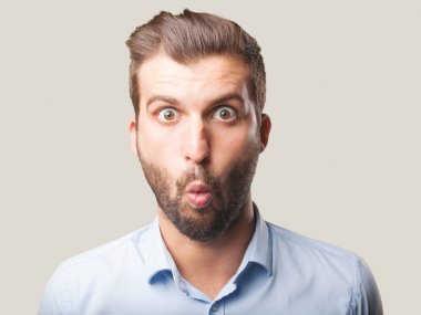 Genç yakışıklı adam mavi t gömlek giymiş şok ve endişeli veya ifade hayran. Tek renkli arka planı izole kişi.