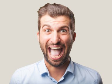 genç yakışıklı adam mavi t gömlek ve mutlu ya da memnun ifade şaşırttı. Tek renkli arka planı izole kişi.
