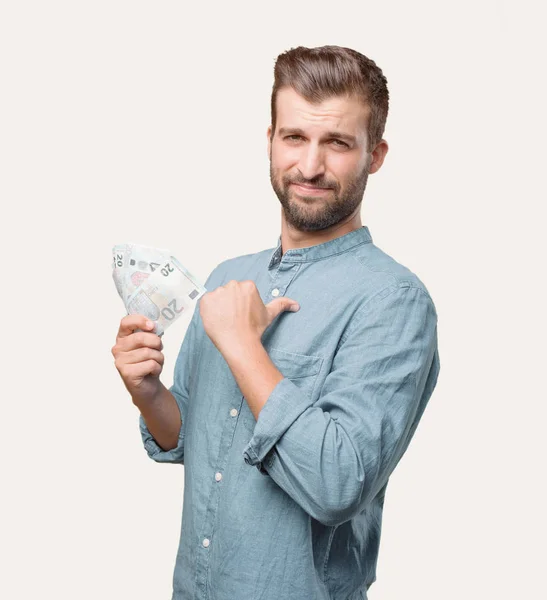 年轻英俊的男子 蓝色牛仔衬衫 欧元钞票 满意和庆祝他的成功 钱的概念 独立于单色背景的人 — 图库照片