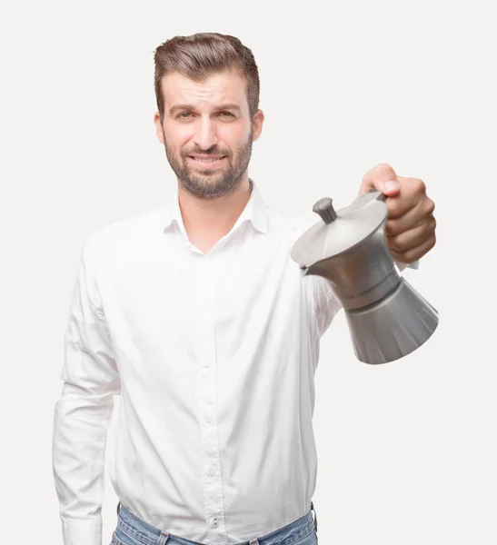 Jovem Bonitão Segurando Uma Cafeteira Vestindo Camiseta Branca Pessoa Isolada — Fotografia de Stock