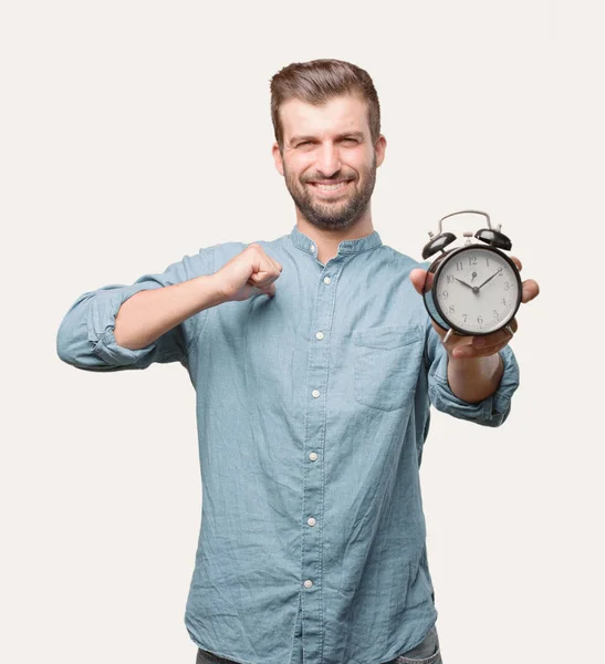 Joven Hombre Guapo Sosteniendo Reloj Despertador Con Una Camisa Mezclilla —  Fotos de Stock