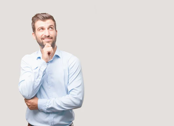 Ein Junger Gutaussehender Mann Der Einem Blauen Shirt Denkt Oder — Stockfoto