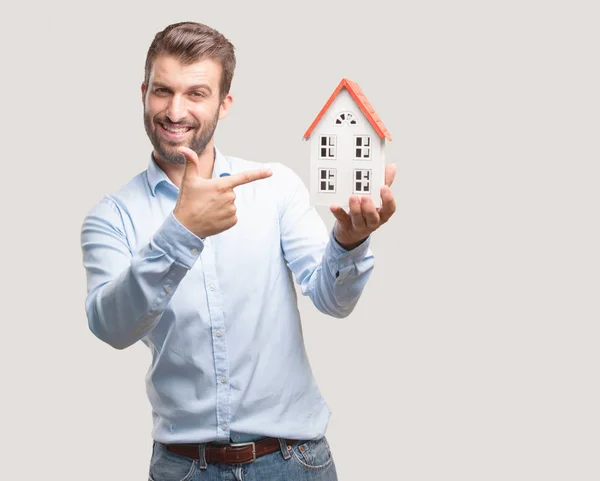 Ein Junger Gutaussehender Mann Mit Einem Hausmodell Einem Blauen Shirt — Stockfoto