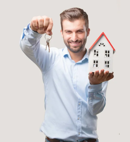 Ein Junger Gutaussehender Mann Mit Hausmodell Und Schlüssel Einem Blauen — Stockfoto