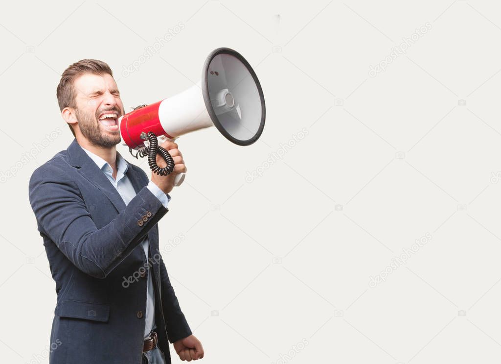 Young handsome businessman, blue blazer, shouting on a megaphone. Angry expression. Person isolated against monochrome background.