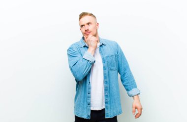 Genç sarışın adam beyaz arka plana karşı bir kavram ifade ediyor.
