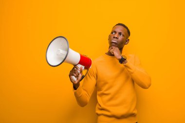 Genç Afro-Amerikan siyahi adam turuncu duvara karşı megafonla