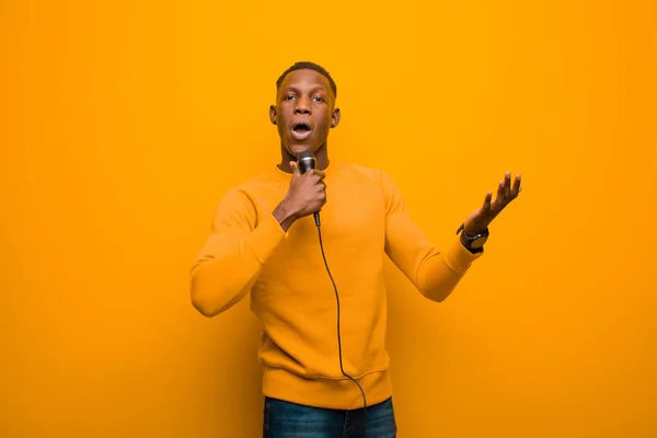 Junger Afrikanisch Amerikanischer Schwarzer Mit Mikrofon Gegen Orangefarbene Wand — Stockfoto
