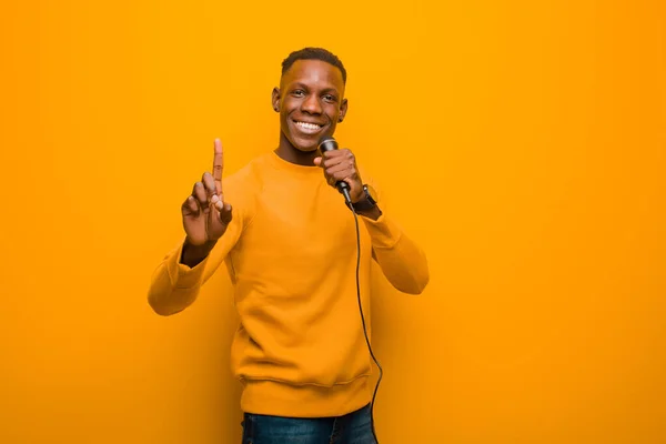 Jovem Negro Afro Americano Contra Parede Laranja Com Microfone — Fotografia de Stock