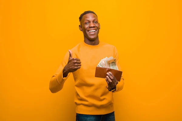 Hombre Negro Afroamericano Joven Contra Pared Naranja Concepto Dinero —  Fotos de Stock