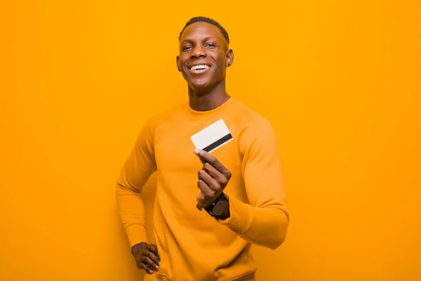 年轻的非洲裔美国黑人男子对抗橙色墙 金钱概念 — 图库照片