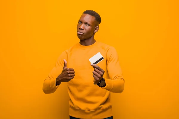 Νεαρός Αφροαμερικάνος Μαύρος Ενάντια Στον Πορτοκαλί Τοίχο Έννοια Του Χρήματος — Φωτογραφία Αρχείου