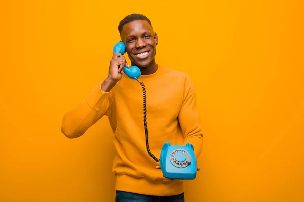 Jovem Negro Afro Americano Contra Parede Laranja Com Telefone Vintage — Fotografia de Stock