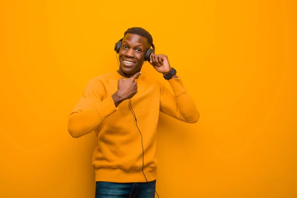 Joven Afroamericano Negro Hombre Contra Pared Naranja Con Auriculares —  Fotos de Stock
