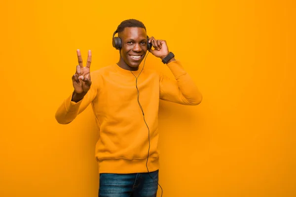 Νεαρός Αφροαμερικανός Μαύρος Ενάντια Πορτοκαλί Τοίχο Ακουστικά — Φωτογραφία Αρχείου