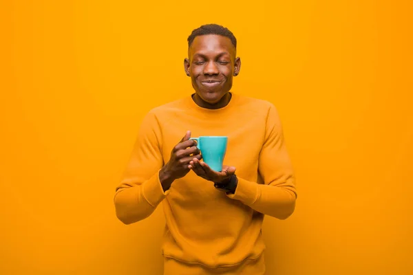 Joven Afroamericano Negro Hombre Contra Pared Naranja Con Una Taza —  Fotos de Stock