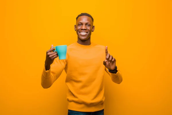 Jovem Negro Afro Americano Contra Parede Laranja Com Uma Xícara — Fotografia de Stock