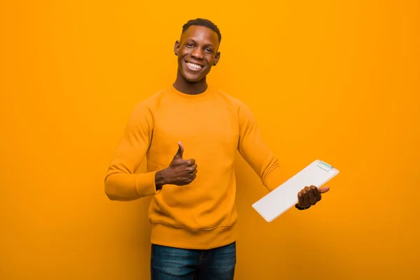 Giovane Afro Americano Nero Uomo Contro Muro Arancione Wholding Cartello — Foto Stock