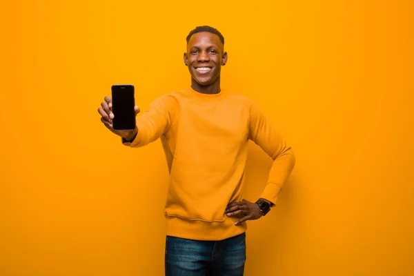 Молодой Афроамериканец Черный Мужчина Против Оранжевой Стены Смартфоном — стоковое фото