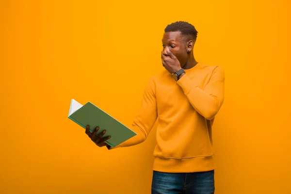 Joven Afroamericano Negro Hombre Contra Pared Naranja Con Libro —  Fotos de Stock