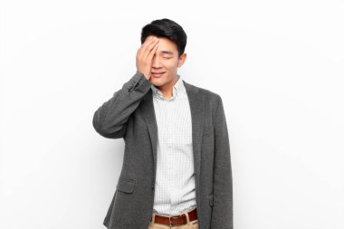 Genç Çinli adam gülüyor ve alnına şaplak atıyor. Unutmuşum yoksa düz duvara karşı yaptığım aptalca bir hataydı. 