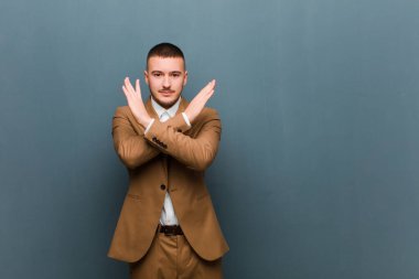 Genç ve yakışıklı iş adamı tavırlarından rahatsız ve bıkkın görünüyor. Yeter artık! Eller önde çapraz, düz arkaplanda durmanı söylüyor.