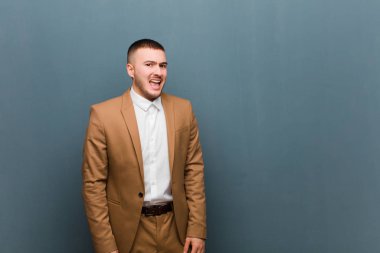 Genç ve yakışıklı iş adamı korkmuş ve şok olmuş hissediyor, ağzı açık ve düz arkaplan karşısında şaşkınlık içinde.