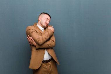 Genç yakışıklı iş adamı aşık, gülümseyen, sarılan ve kendine sarılan bekar, bencil ve benmerkezci biri.