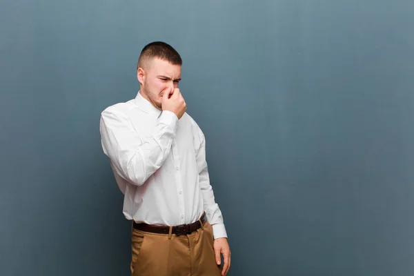 Młody Przystojny Biznesmen Czuje Obrzydzenie Trzymając Nos Aby Uniknąć Wąchania — Zdjęcie stockowe