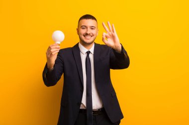 Genç yakışıklı iş adamı arka planda bir ampulle