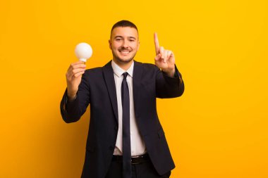 Genç yakışıklı iş adamı arka planda bir ampulle