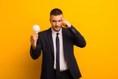 Genç yakışıklı iş adamı arka planda bir ampulle