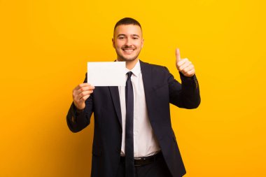 Genç ve yakışıklı bir iş adamı düz bir arkaplan kullanıyor.