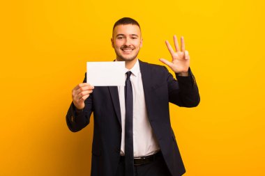 Genç ve yakışıklı bir iş adamı düz bir arkaplan kullanıyor.