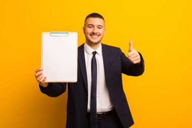 Genç ve yakışıklı bir iş adamı düz bir arkaplan kullanıyor.