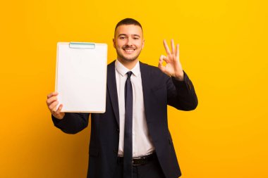 Genç ve yakışıklı bir iş adamı düz bir arkaplan kullanıyor.