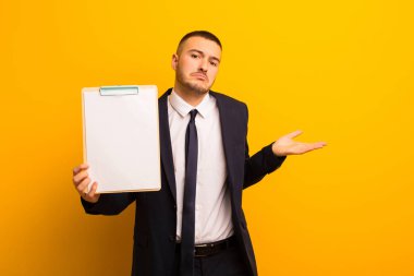 Genç ve yakışıklı bir iş adamı düz bir arkaplan kullanıyor.