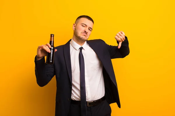 young handsome businessman  against flat background having a beer