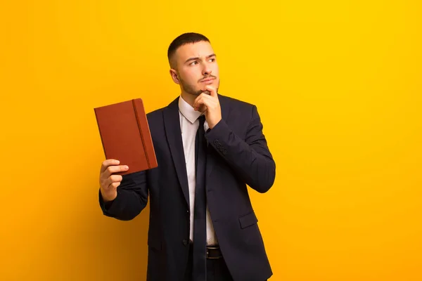 Jonge Knappe Zakenman Tegen Platte Achtergrond Met Een Dagboek — Stockfoto