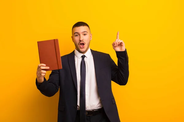 Jovem Empresário Bonito Contra Fundo Plano Com Livro Diário — Fotografia de Stock