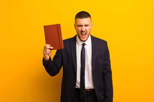 Jovem Empresário Bonito Contra Fundo Plano Com Livro Diário — Fotografia de Stock